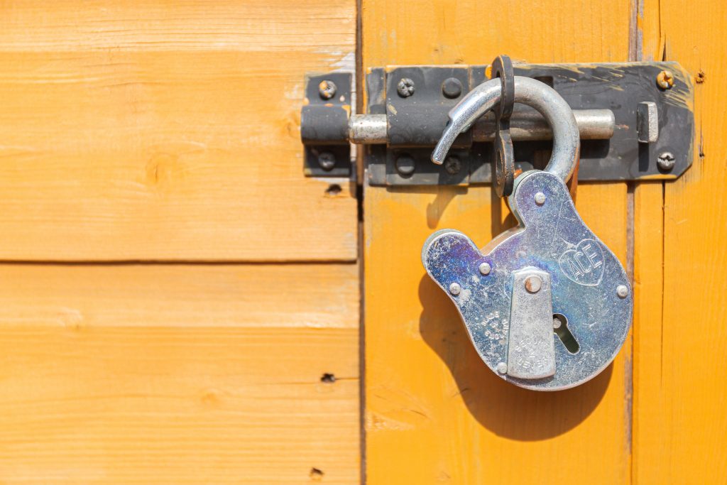 brown wooden door with padlock