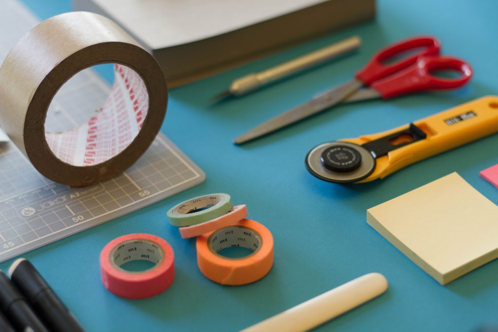 assorted-color office items on blue table