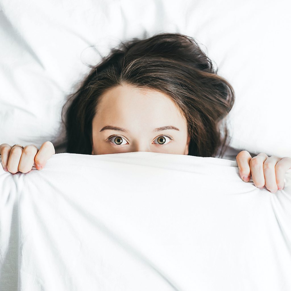 woman peeking from the blanket