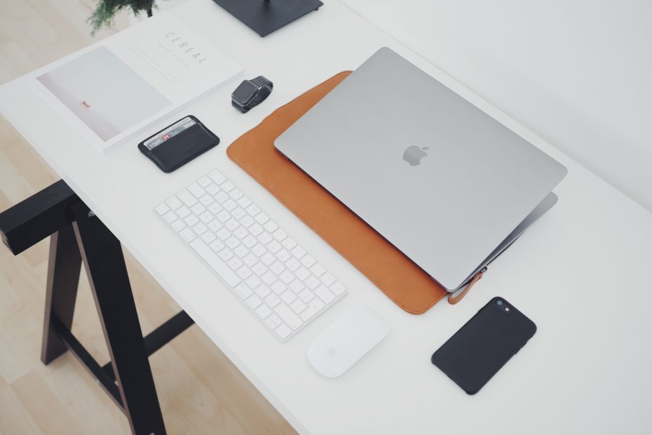 silver MacBook and phone on white table